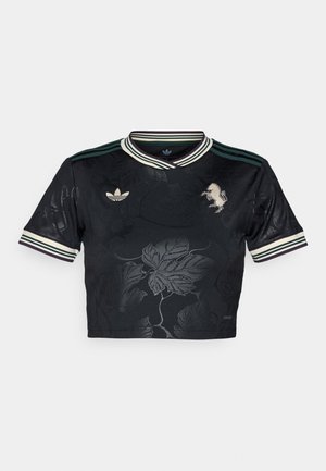 Černý zkrácený jersey s květinovým embosovaným vzorem, tři pruhy na rukávech, vyšívané logo a kontrastní zelený a bílý límec.