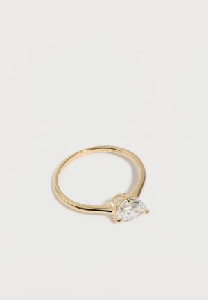 Goldring mit einem großen, klaren, oval geschliffenen Edelstein, der von vier Krappen gehalten wird, vor schlichtem weißem Hintergrund.