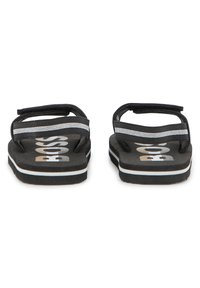 Μαύρα σαγιονάρια με υφή στην σόλα, με διπλές ριγέ μαύρες και λευκές λουρίδες, και έντονη επιγραφή "BOSS" στο πέλμα.