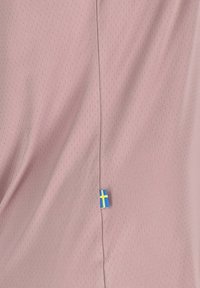 Roze geperforeerde stof met een verticale naad versierd met een klein Zweeds vlaggetje nabij de zoom. Zachte textuur en ademend ontwerp.