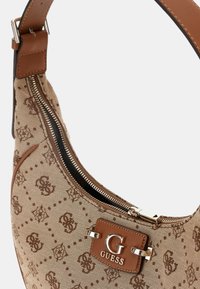 Bolso de hombro marrón claro con un tejido estampado y detalles en cuero marrón, con un cierre metálico plateado y un prominente logo "G" en la parte frontal.