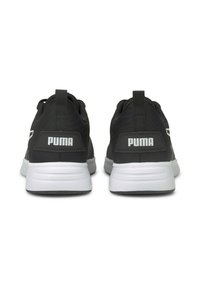 Schwarze Sportschuhe mit einem glatten Stoffoberteil, weißer Sohle und auffälliger PUMA-Branding an der Ferse und an der Seite. Die Rückansicht zeigt Zuglaschen.