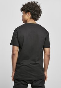 Svart bomull T-skjorte med korte ermer, rund hals og ensfarget design. Myk tekstur og standard passform.