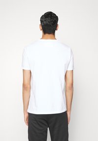 Vit bomull t-shirt med rund halsringning, korta ärmar och rak nederkant. Enkelt design, utan mönster eller dekorationer.