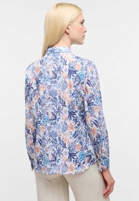 Lange mouwen shirt van licht materiaal met een bloemenpatroon in blauwe, perzik- en groene tinten, met een kraag en knoopmanchetten.