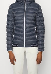 Dunkelgraue Pufferjacke mit Reißverschluss, horizontal gestepptem Design, elastischen Bündchen und einem logobeschrifteten Band am Saum. Hat eine Kapuze und seitliche Taschen.