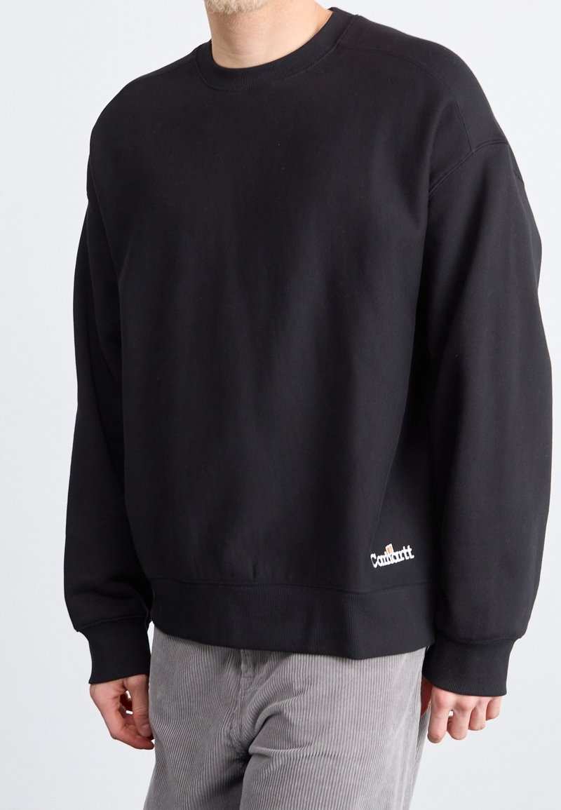 Zwarte sweatshirt met een ronde hals, ribgebreide manchetten en zoom. Voorzien van een klein wit logo op de voorkant links. Gemaakt van zachte, middelzware stof.