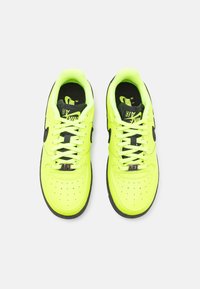 Neon yellow leather sneakers with black accents, perforated toe, flat laces, and rubber sole; features "AFL" branding on the tongue.