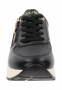 Sneaker nera con design a lacci, dotata di chiusura laterale con zip e suola in gomma di colore crema a contrasto. Texture in pelle liscia e accenti minimi.