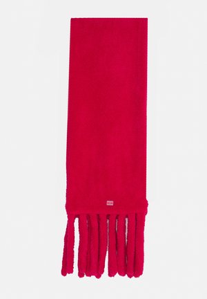 Écharpe en laine rouge vif avec de longues franges épaisses à une extrémité et un petit logo rectangulaire près du bord de la frange, présentée à plat sur un fond blanc.