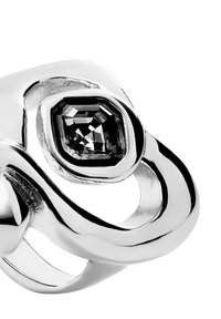 Anillo de plata con diseño retorcido y una piedra negra en corte esmeralda engastada en un marco pulido. Textura suave con acentos contrastantes.