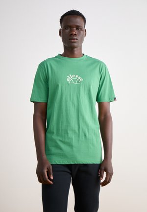 Camiseta de algodón verde con mangas cortas, cuello redondo, que presenta el logo blanco de "ellesse" en el pecho. Color sólido, corte relajado.