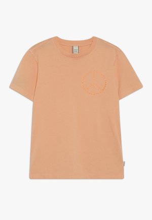 T-shirt en coton couleur pêche avec des manches courtes, col rond et un logo embossé circulaire sur la poitrine. Texture lisse, coupe décontractée.