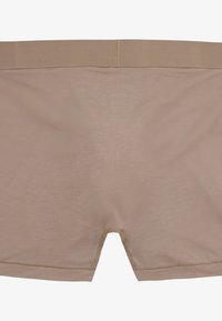 Beżowe bezszwowe bokserki wykonane z elastycznego materiału, z miękkim pasem i gładką, lekką teksturą.
