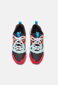 Farverige sneakers med en sort mesh-overdel, røde suede-detaljer og blå og orange accenter. Hvide snørebånd med blå prikker.