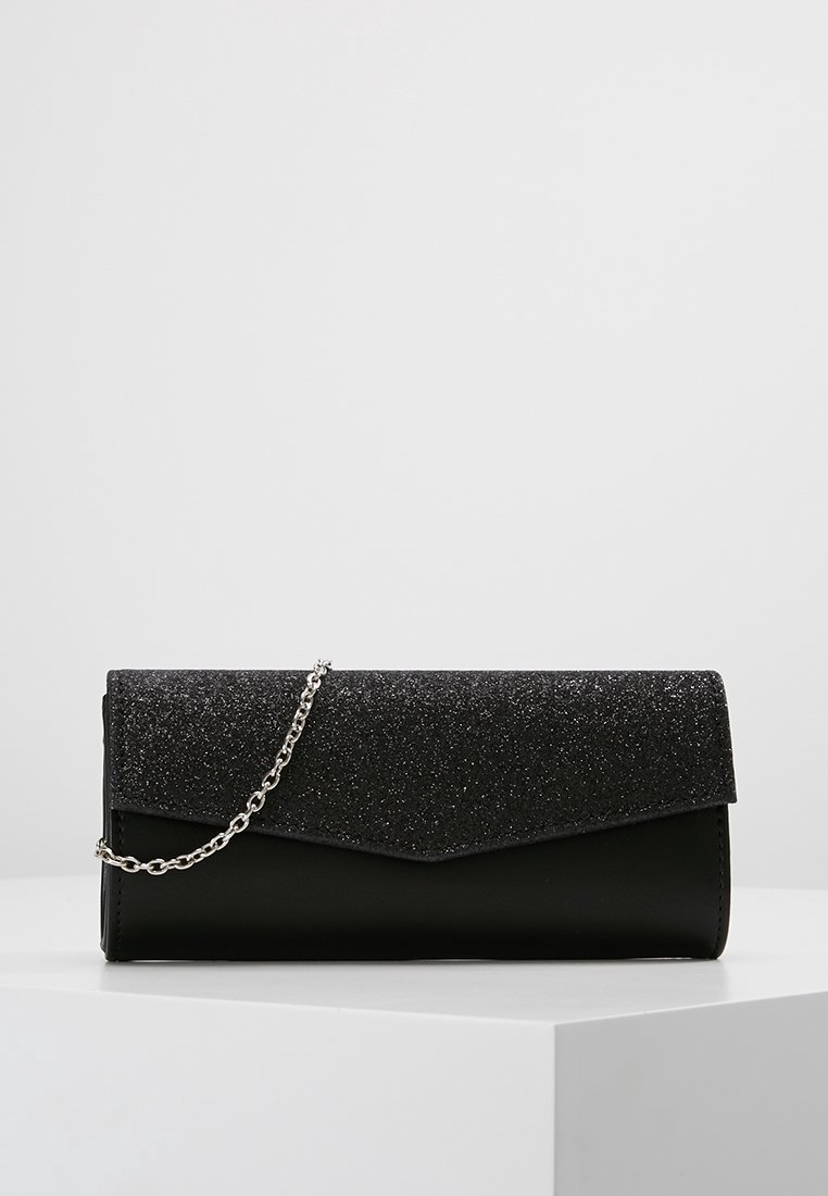 Pochette noire avec un rabat scintillant, dotée d'une bandoulière en chaîne argentée. Texture lisse au fond, finition mate sur le rabat.