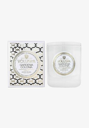 Gennemsigtig glaskande med et låg med guld- og sort mønster. Emballagen inkluderer en hvid æske med guldaccentuer og fed skrift, der mærker "VOLUSPA GARDENIA COLONIA."