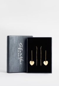 Orecchini a forma di cuore in oro con dettagli a catena, esposti in una scatola di velluto nero. La scatola presenta un'esterno in argento texturizzato.