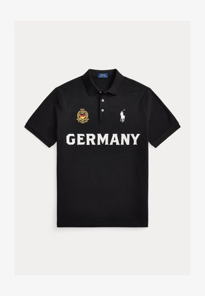 Μαύρο πόλο με τη λέξη "GERMANY" σε λευκό, το λογότυπο Polo Ralph Lauren στο δεξί στήθος και ένα κεντημένο χρυσό και μαύρο σήμα στο αριστερό στήθος.
