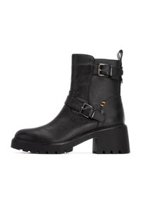 Stivaletto nero in pelle sintetica con tacco chunky, dotato di due cinturini regolabili con fibbie e una suola testurizzata.