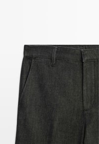 Pantaloni in denim nero con fronte piatto, due tasche laterali e dettagli di cucitura sottili, progettati per un fit sartoriale.