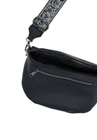 Borsa a tracolla in pelle blu navy con la zip principale parzialmente aperta, tasca frontale con zip e tracolla regolabile con motivo a righe bianco e nero.