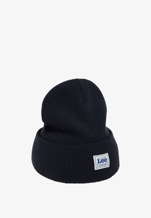 Marineblaues geripptes Strickmütze mit umgeschlagenem Bund und einem weißen Etikett mit dem "Lee"-Logo. Weiche Textur und klassischer Schnitt.