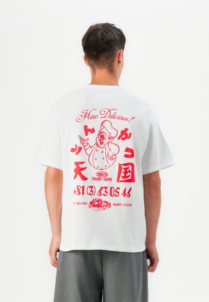Camiseta de algodón blanca con estampado gráfico rojo en la parte posterior, que representa a un chef, texto y un gráfico de pizza. Mangas cortas, corte relajado.