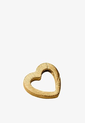 Anillo metálico en forma de corazón de color dorado con una textura rugosa y una sutil grieta sobre un fondo blanco.