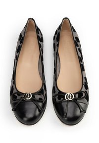Un paio di ballerine da donna nere e grigie con stampa leopardata, con punte nere e fiocchi decorativi con anelli argentati.