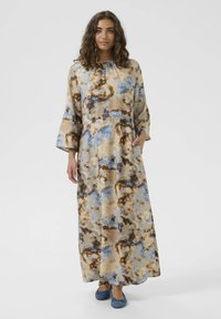 Pitkä, virtaava mekko, jossa on ruskea, sininen ja beige abstrakti kuvio. Mukana pitkät hihat, kerrostettu kaula-aukko ja sivutaskut.