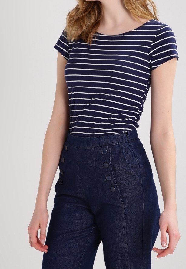 Marineblå og hvidstribet kortærmet t-shirt parret med højtaljede mørkeblå denimbukser med knapdetaljer på siden.