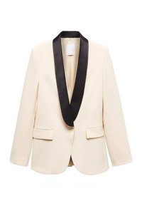 Blazer beige avec col châle en satin noir, deux poches, et fermeture à un seul bouton. Design cintré avec une texture lisse.