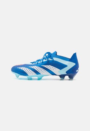 Chaussure de football bleue avec un motif texturé et des accents blancs, dotée d'un design profil bas et de crampons de traction transparents.