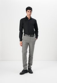 Black button-up shirt, patterned gray trousers, black belt, and black shoes. Slim fit, smooth fabric, and geometric design on the pants.