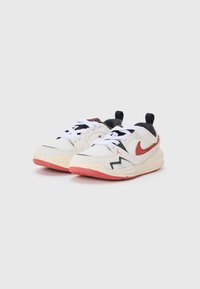 Białe sneakersy z teksturowanym siateczkowym wierzchem, czerwonymi i czarnymi akcentami, logo po boku, czarnymi sznurowadłami i różową gumową podeszwą.