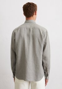 Herrenhemd mit langen Ärmeln in Hellgrau mit dünnen blauen Streifen, ausgestattet mit einem spitzen Kragen und geknöpften Manschetten; aus weichem Stoff gefertigt.