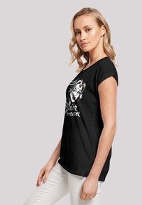 Black t-shirt featuring a graphic print of a woman with a headband, short sleeves, and a relaxed fit.  Soft cotton fabric.
