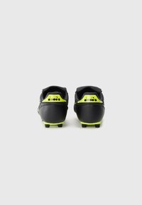 Black soccer cleats with a smooth synthetic upper, featuring neon yellow accents and a textured heel. Studded outsole for traction.