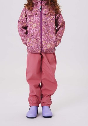 Fialová vzorovaná bunda se zipem a kapsami, spárovaná s růžovými nepromokavými kalhotami a fialovými gumovými botami s černými podrážkami.