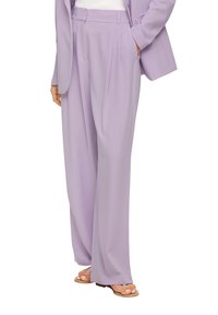 Lavendelkleurige geplooide broek van lichtgewicht stof, met een hoge taille, zijzakken en een relaxte pasvorm. Gecombineerd met neutrale sandalen.