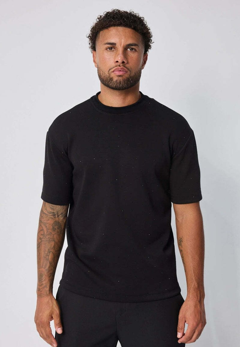 T-shirt noir à manches courtes avec col rond, fabriqué en tissu doux, présentant des mouchetures subtiles, un ourlet droit et une coupe décontractée.