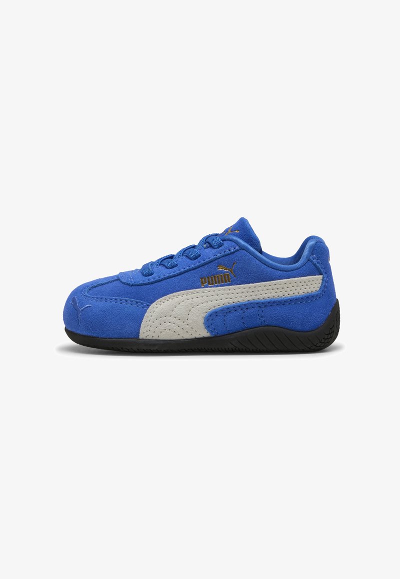 Blue suede sneaker with grey accents, featuring a textured design, black rubber sole, and gold logo detailing on the side.