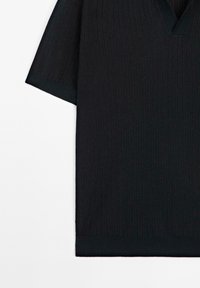 Top corto a maniche corte in maglia a coste scura con scollo a V, dotato di una finitura testurizzata e bordi in contrasto scuro sullo scollo e sulle maniche.