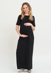 Schwarzes Umstandsmode-Maxi-Kleid mit kurzen Ärmeln, aus weichem Stoff gefertigt, mit entspanntem Schnitt und glatter, fließender Textur.