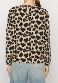Leopardenmuster Bluse in Beige und Schwarz, mit langen Ärmeln mit elastischen Bündchen, einem Schlitz auf der Rückseite und einem lockeren Schnitt.