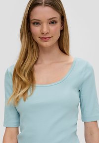 Lichtblauw ribbelshirt met een ronde halslijn en korte mouwen. De stof heeft een gladde textuur en een aansluitend ontwerp.