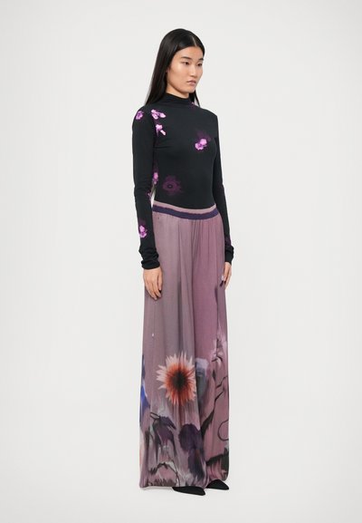 Black long-sleeve top with purple floral patterns, paired with a flowing, multi-colored maxi skirt featuring floral prints in shades of pink and lavender.