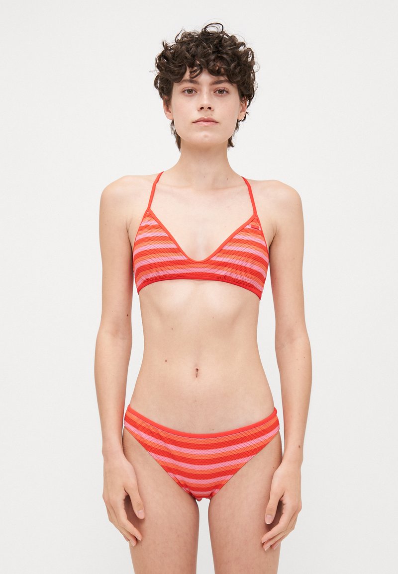 Rood en roze gestreepte bikini set met een triangulaire bralette top en bijpassende low-rise broekjes, gemaakt van glad, rekbaar materiaal.