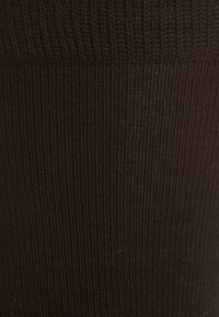 Czarne prążkowane legginsy wykonane z elastycznego materiału, charakteryzujące się jednolitą teksturą z pionowymi liniami, odpowiednie do codziennego użytku.